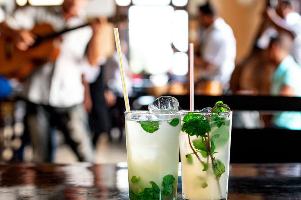 Tropische cocktailbar - Mojito cocktailbar met flessen rum en verse limoen, live muziek en gezellige danseressen